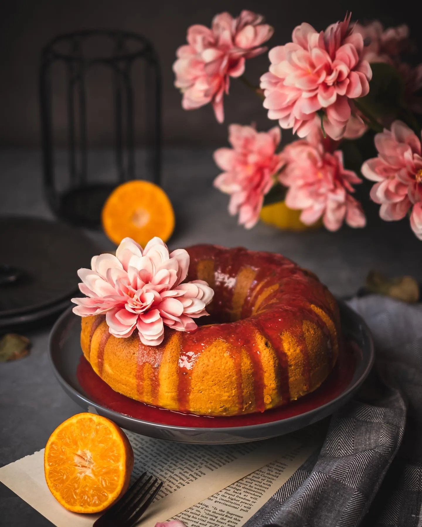 Orange bundt cake with pink flowers and orange slices – cake photography by My Pinch of Wow, Dubai