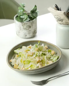 Green salad with creamy dressing in a white bowl – healthy menu photography, Dubai