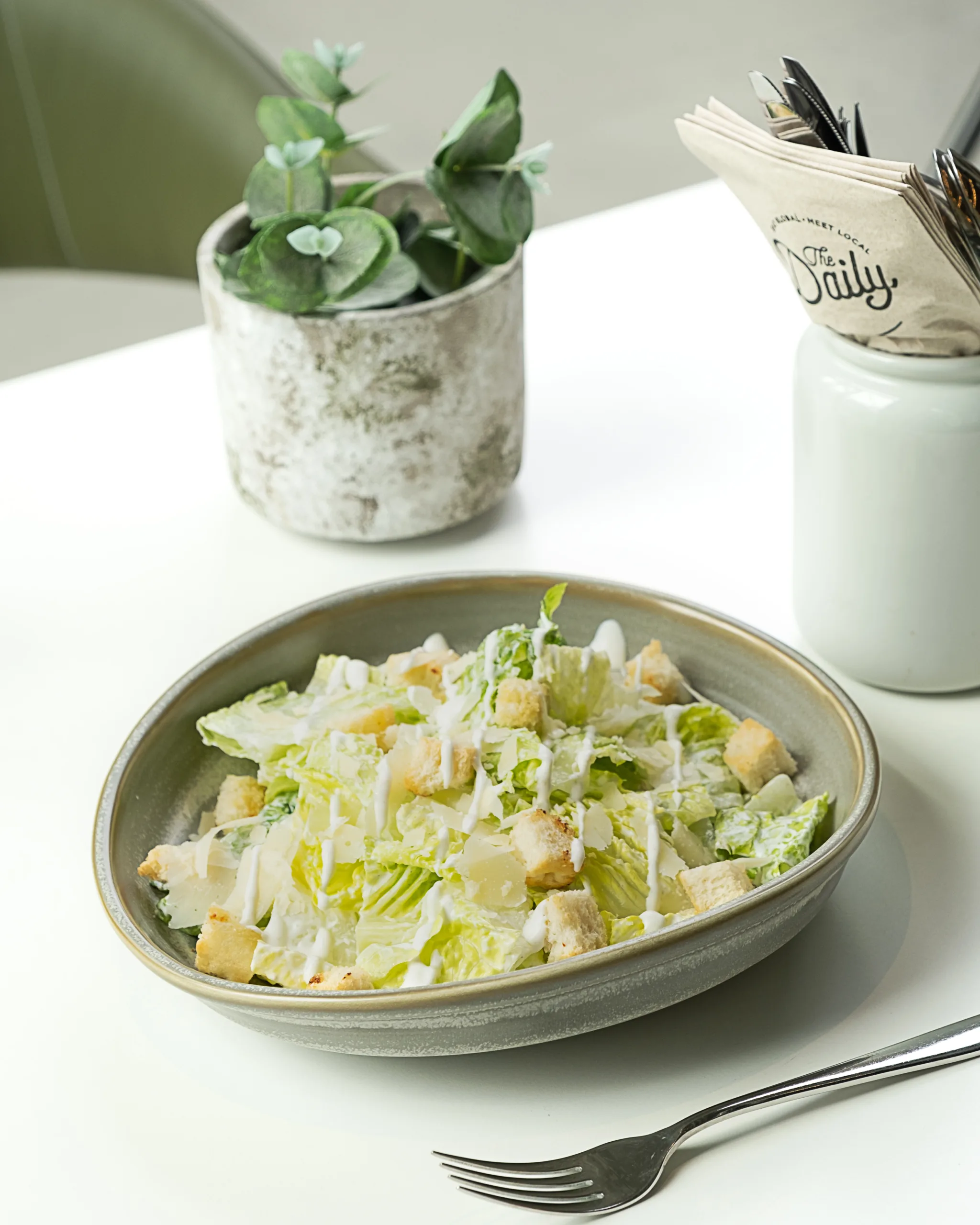 Green salad with creamy dressing in a white bowl – healthy menu photography, Dubai