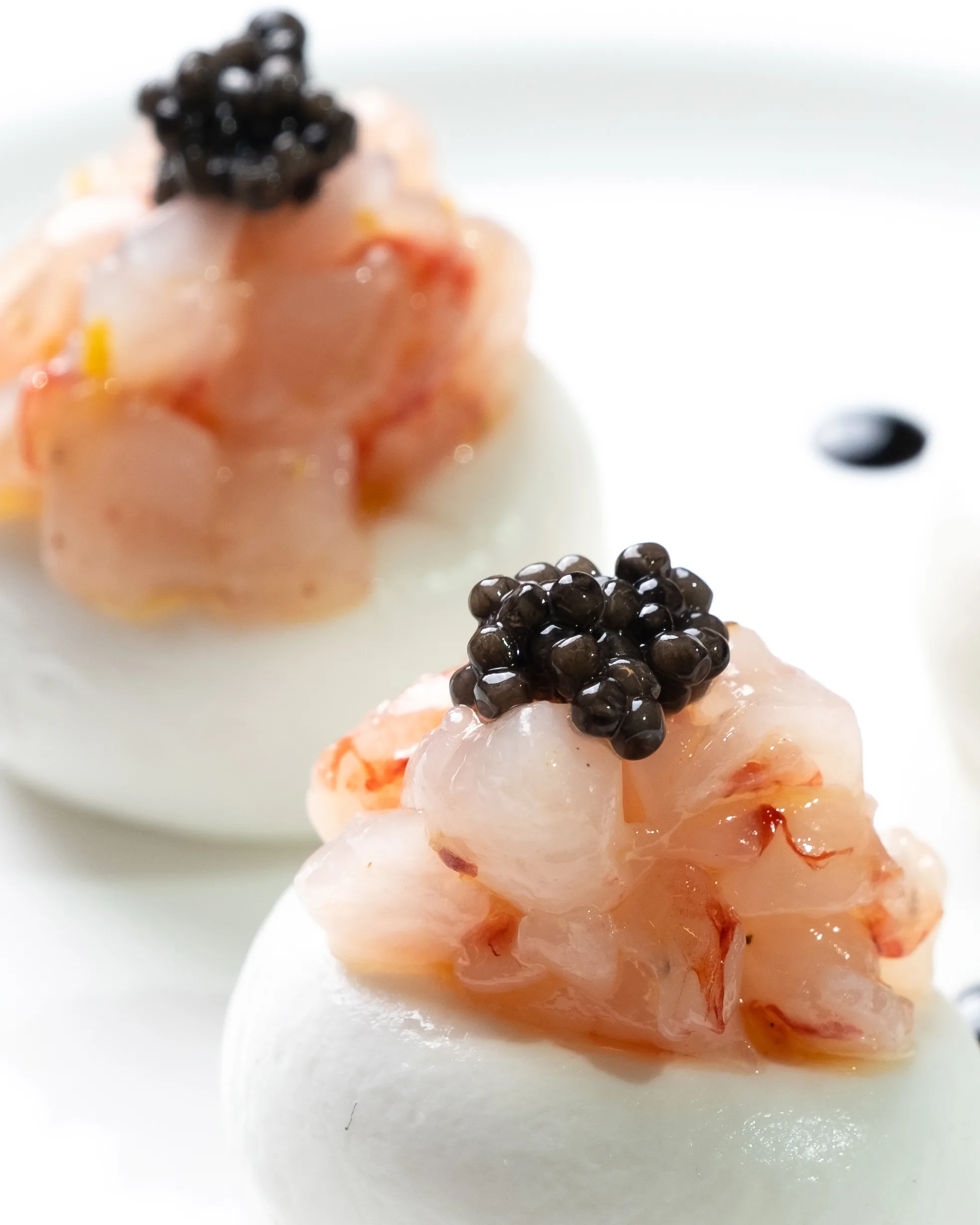 Prawn tartare crowned with black caviar on a white plate – luxury restaurant food photography, Dubai
