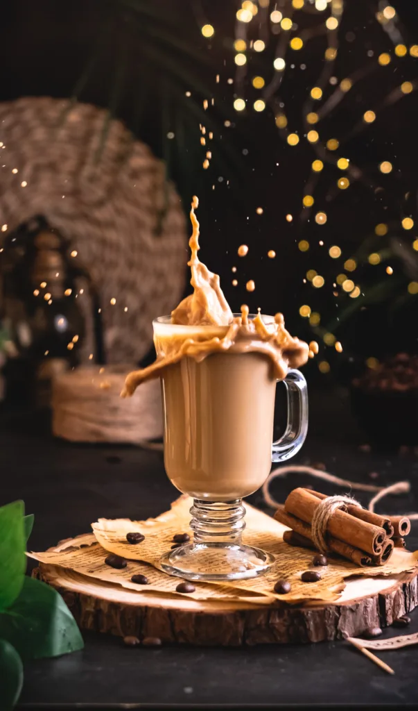 Coffee splashing out of a glass mug with cinnamon sticks – action beverage photography, Dubai