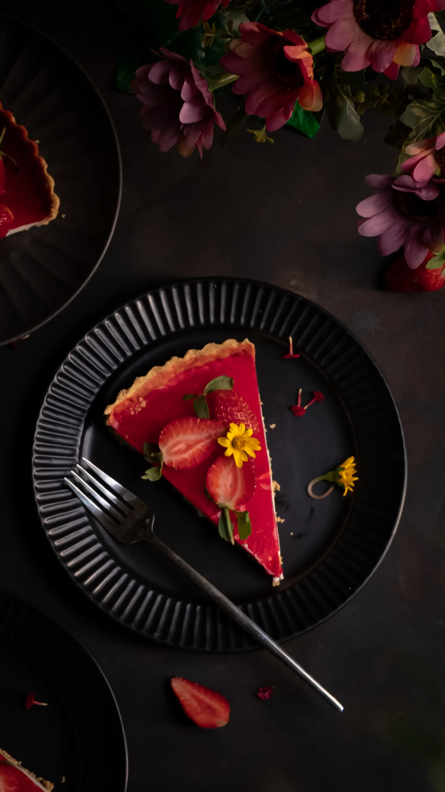 Strawberry tart slice on a black plate with flowers – dessert photography by My Pinch of Wow, Dubai