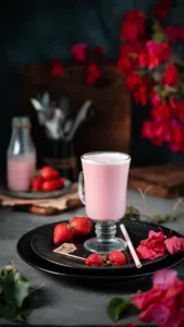 Pink strawberry milkshake in a glass mug with fresh strawberries – café drink photography, Dubai