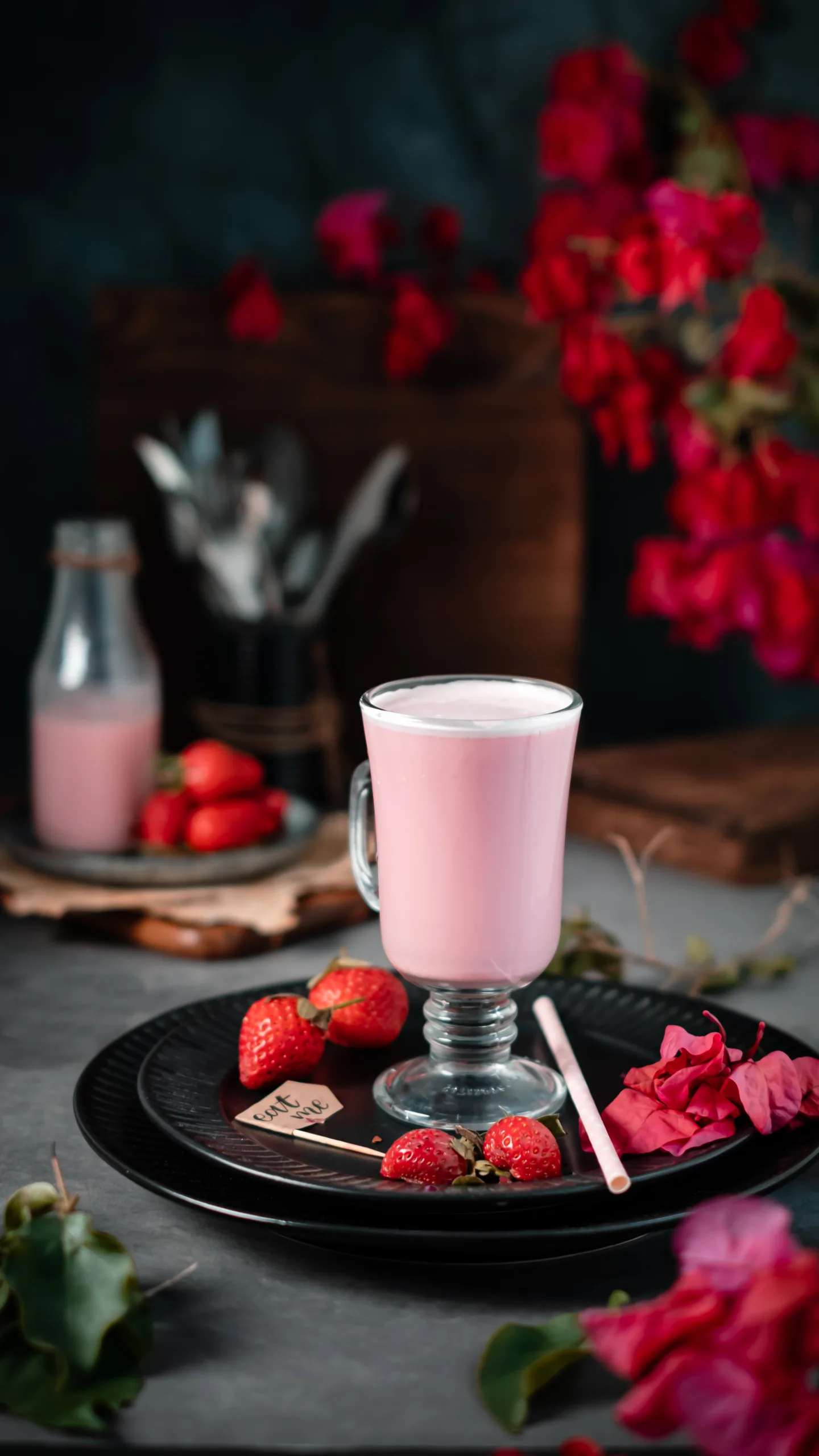 Pink strawberry milkshake in a glass mug with fresh strawberries – café drink photography, Dubai