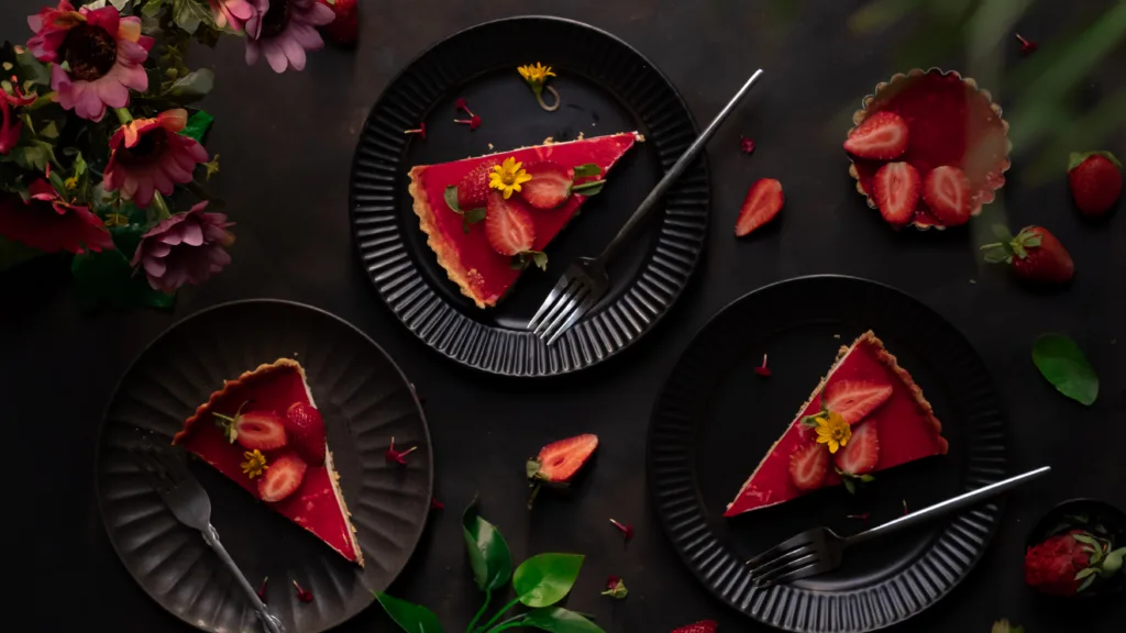 Styled strawberry tart slices on dark plates – food styling and photography by Shameema Abdul Shukoor