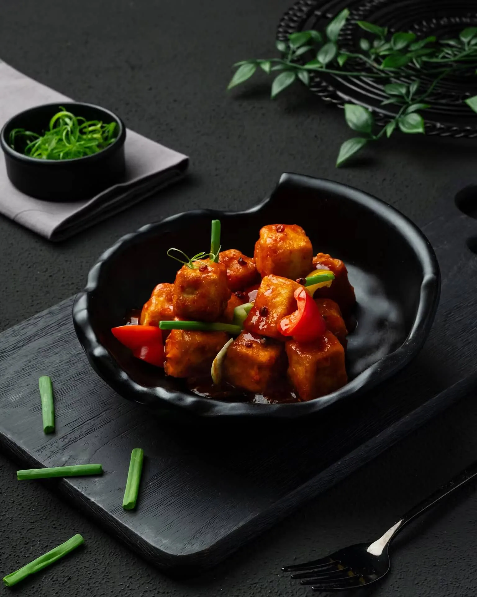 Chilli chicken cubes with peppers in a black bowl – Indo-Chinese restaurant menu photography, Dubai