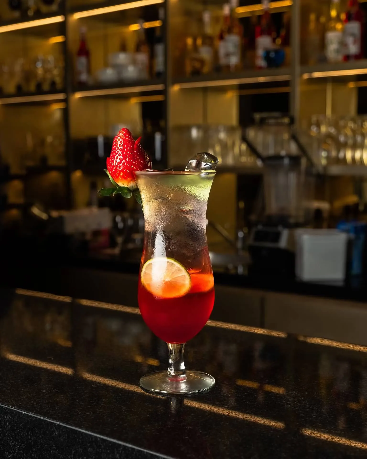 Red berry cocktail with a strawberry garnish at a bar – drink photography, Dubai