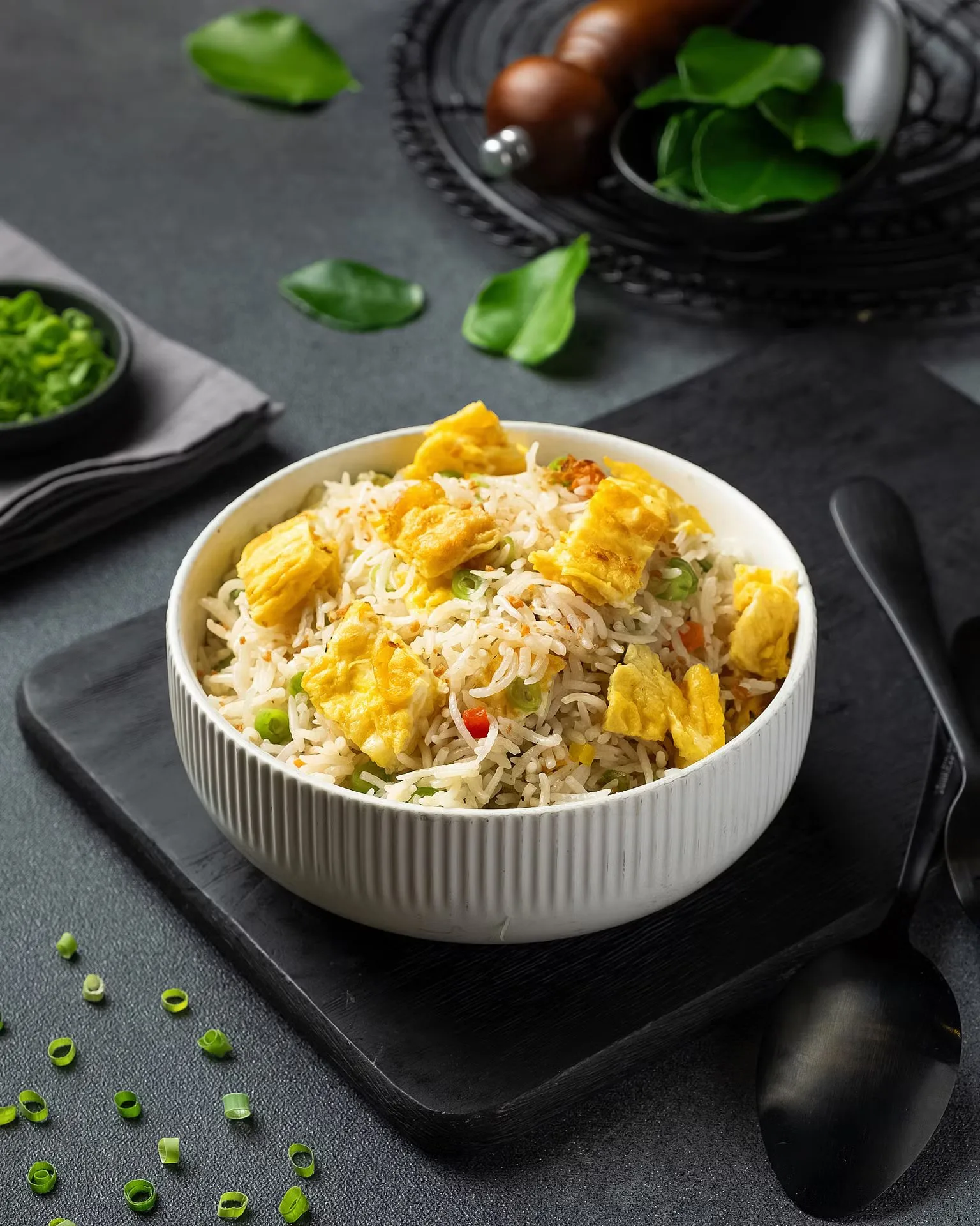 Chicken biryani in a white bowl on dark slate – restaurant menu photography, Dubai