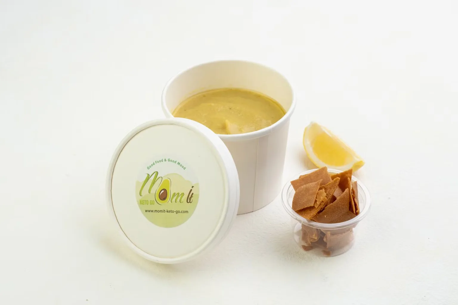 Soup in a takeaway cup with crackers and lemon – delivery-app menu photography, Dubai