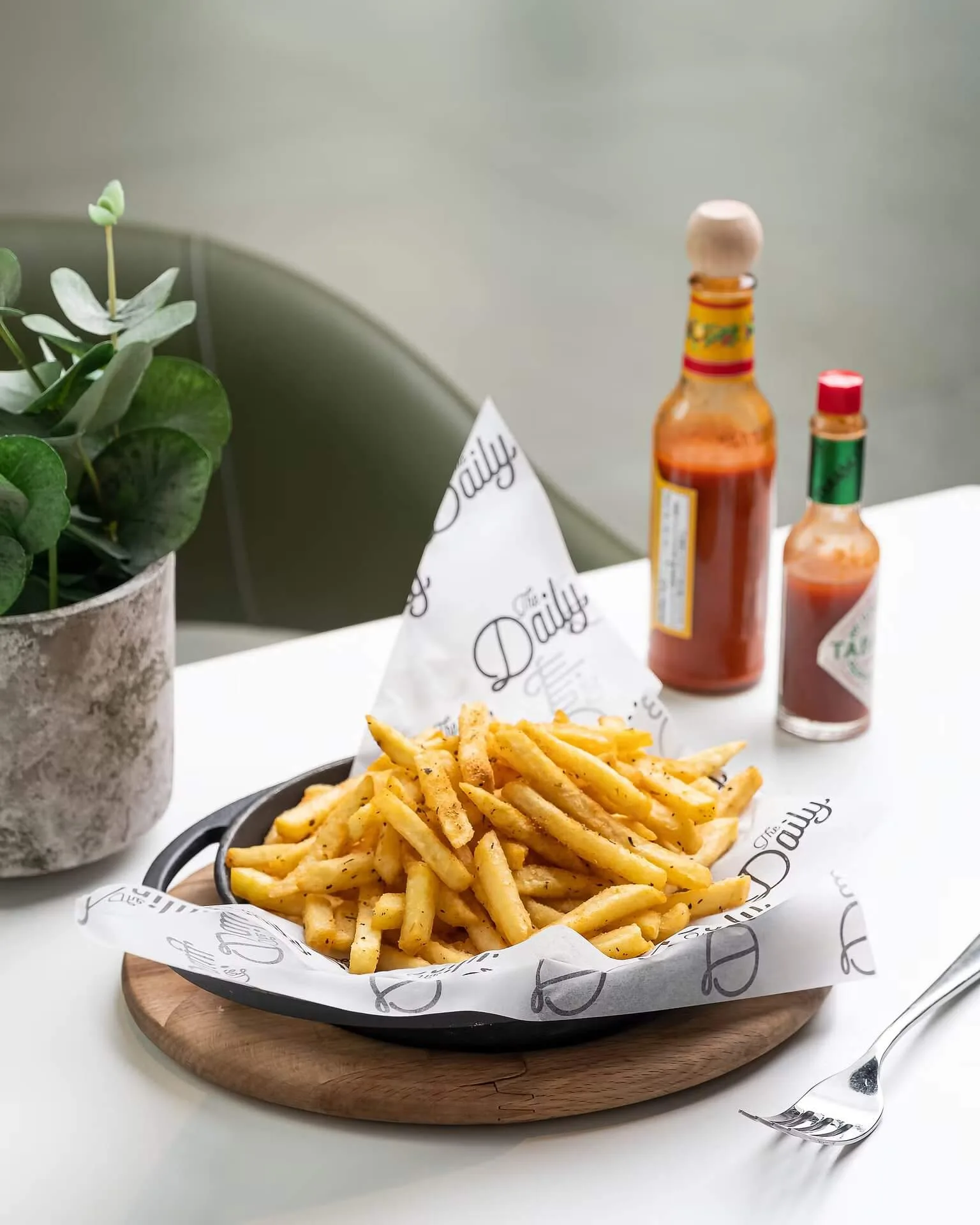 Crispy golden french fries in a paper-lined basket with sauces – fast-food photography, Dubai