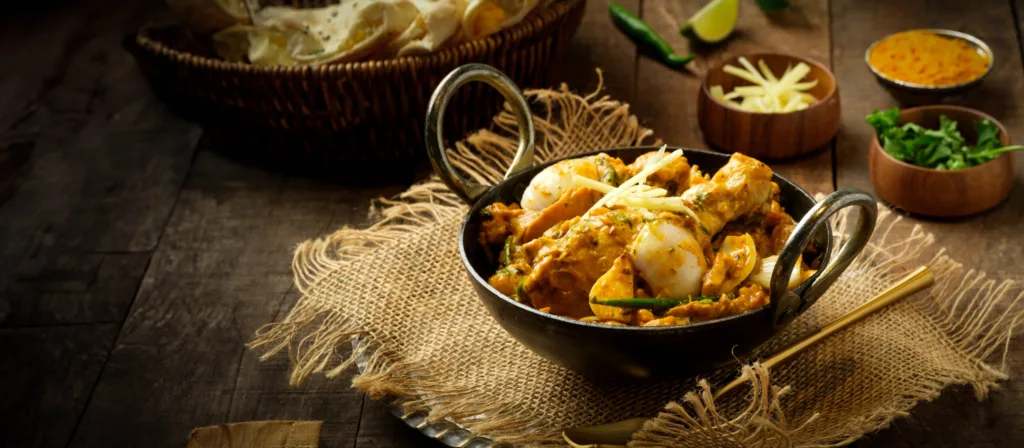 Chicken curry in a copper kadai with fresh herbs – restaurant food photography, Dubai