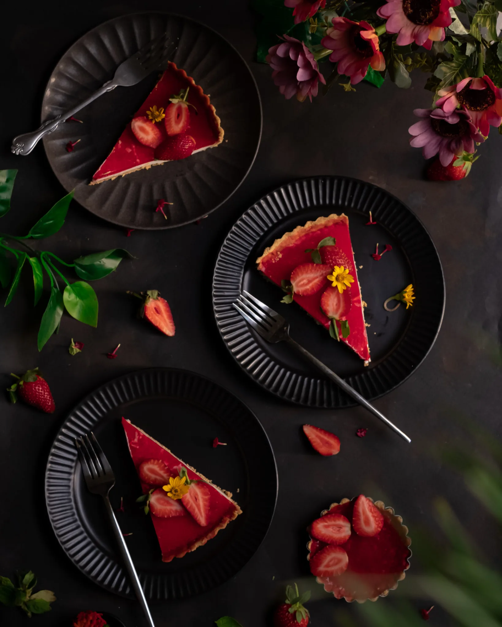 Styled strawberry tart slices on dark plates – food styling and photography by Shameema Abdul Shukoor, Dubai